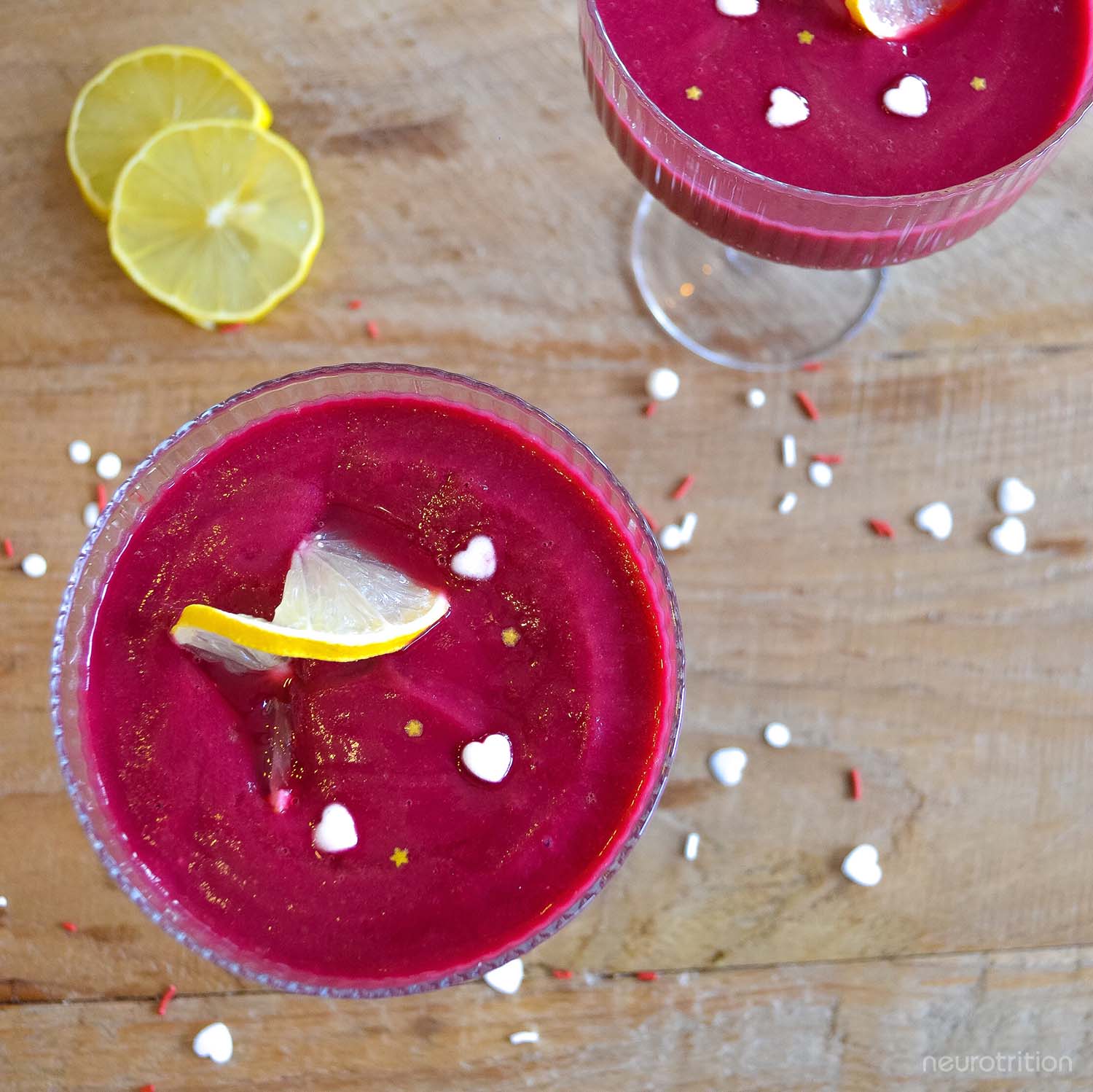 Strawberry Lemonade Detox Smoothie Two bright pink smoothies in cocktail glasses, with lemon twists and heart and star sprinkles.