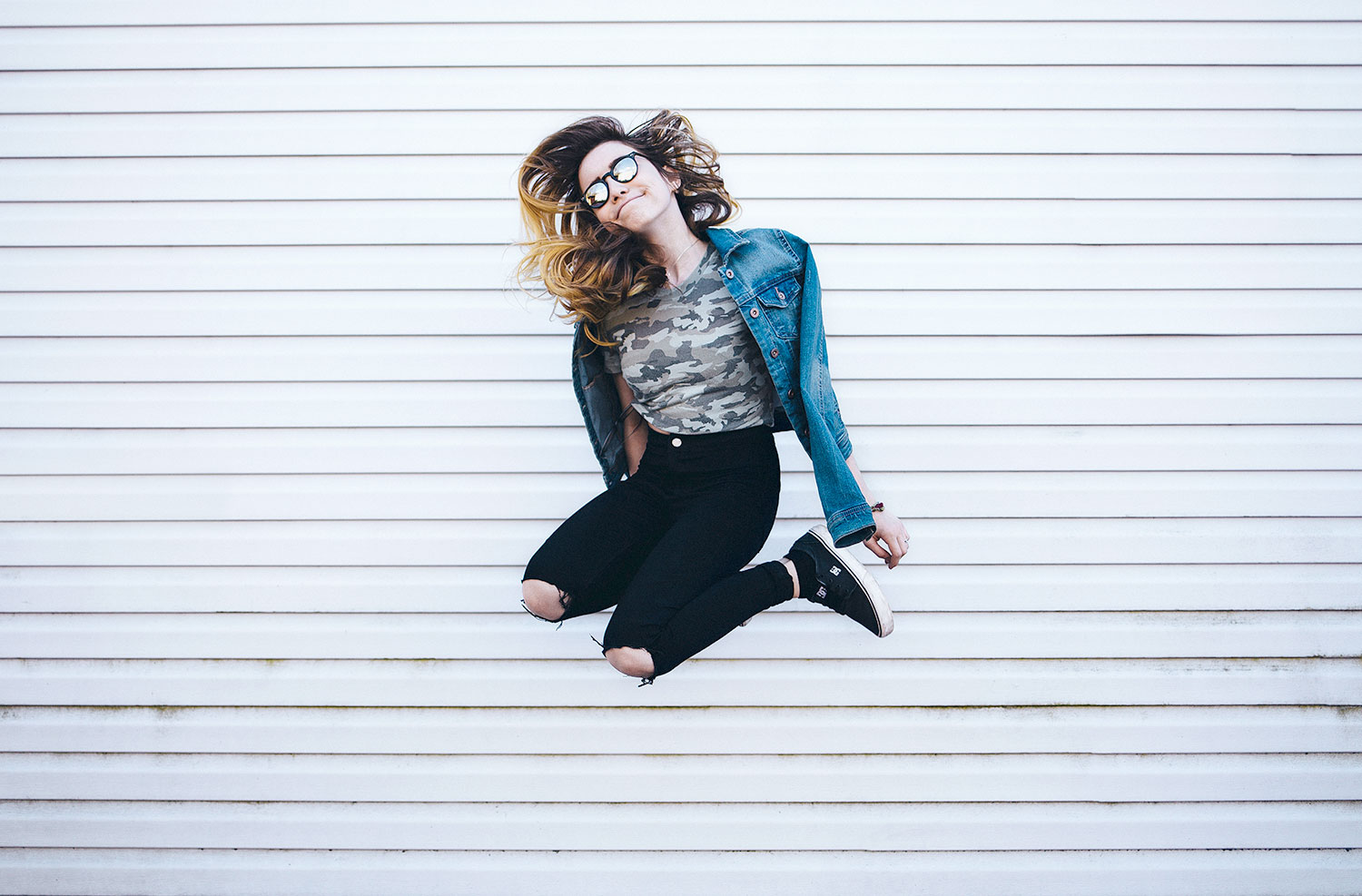 Our Brains Or Our Gut Bugs: Who’s Actually In Control? Woman jumping in front of wall.